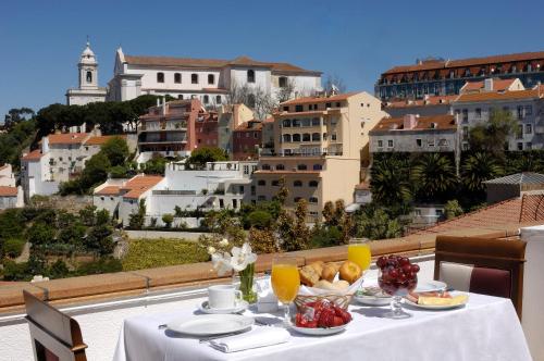 un tavolo con cibo sopra con vista sulla città di Olissippo Castelo a Lisbona