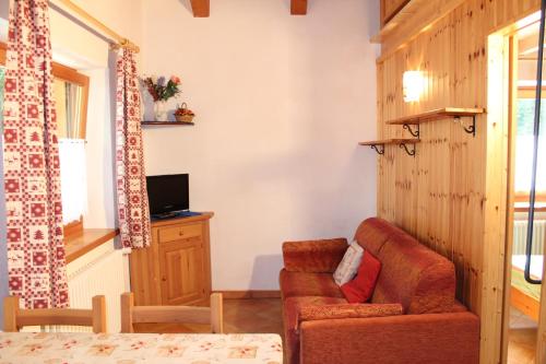a living room with a chair and a television at Camping Du Parc in Pré-Saint-Didier