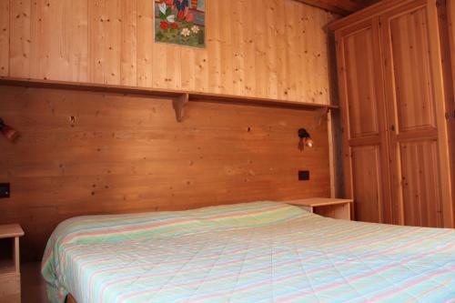 a bedroom with a bed with a wooden wall at Camping Du Parc in Pré-Saint-Didier