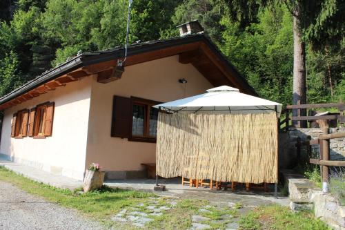 a small house with an umbrella in front of it at Camping Du Parc in Pré-Saint-Didier