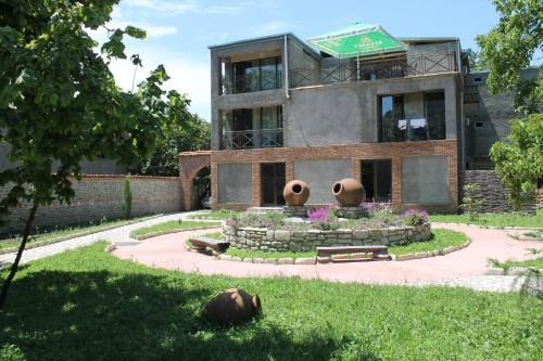 a building with two large vases in front of it at Hotel Kavkasioni in Kvareli