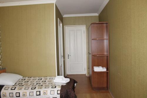 a bedroom with a bed and a book shelf at Hotel Kavkasioni in Kvareli
