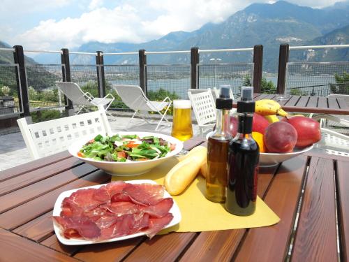 a table with meat and vegetables and bottles of wine at Garden View in Anfo