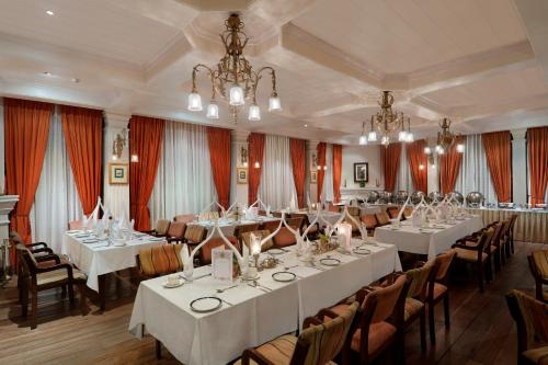 a large banquet room with white tables and chairs at The Elgin, Darjeeling - Heritage Resort & Spa in Darjeeling