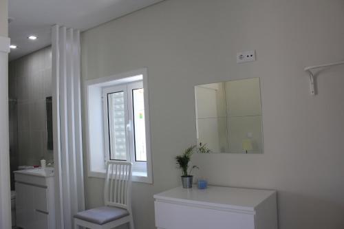 y baño con aseo, lavabo y espejo. en Vivenda Mendes 2 en Vila Nova de Famalicão