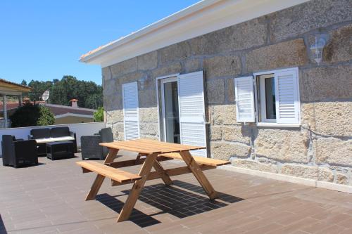 a wooden picnic table in front of a stone building at Vivenda Mendes 2 in Vila Nova de Famalicão