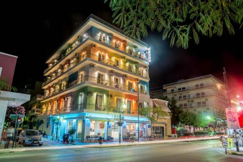 a tall building on a city street at night at CiTYZen Hotel in Loutraki