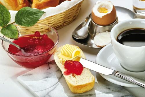 a table with a sandwich and a cup of coffee at Wohnung Zur Post in Bruck an der Großglocknerstraße