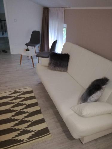 a white couch in a living room with two fuzzy pillows at Villa Aba apartments in Sarajevo