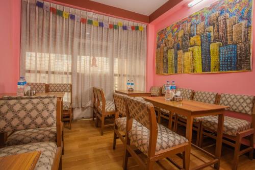 a dining room with tables and chairs and a painting on the wall at Hotel Green Orchid in Kathmandu