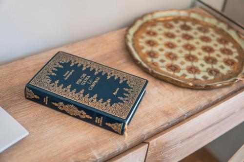 a book sitting on a table next to a pizza at Villa La Lumia B&B Suites & Apartments in Agrigento