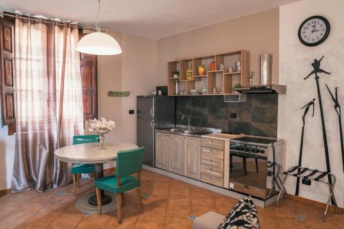 a kitchen with a table and a table and a clock at Villa La Lumia B&B Suites & Apartments in Agrigento