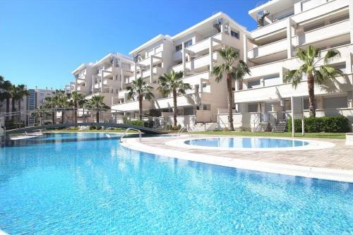a large swimming pool in front of a building at Sea view Penthouse Denia, ELEGANCE in Denia