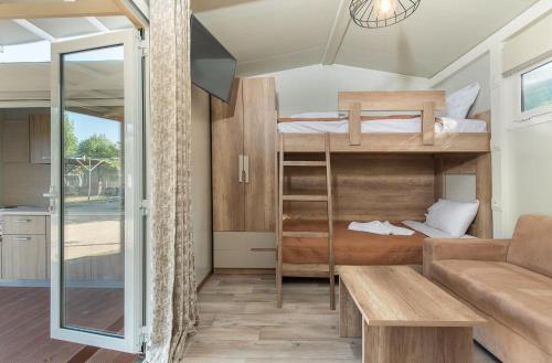um pequeno quarto com beliches e um sofá em Camping Tsitreli em Kalamitsi