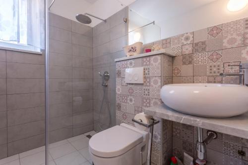a bathroom with a toilet and a sink at Studio Villa Ivka in Baška