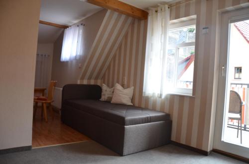 a living room with a black ottoman and a window at Hotel Wehlener Hof in Stadt Wehlen