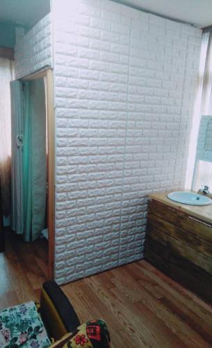 a bathroom with a tub and a sink in a room at Travellersdou Kirinya in Uji