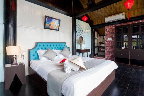 a bedroom with a large white bed with two pillows at An Bang Stilt House Villa in Hoi An