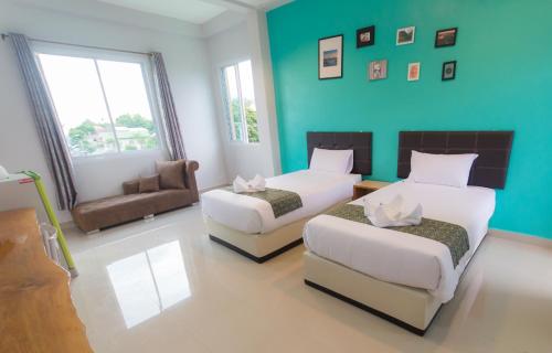 Habitación de hotel con 2 camas y sofá en Ubon Best Place, en Ubon Ratchathani