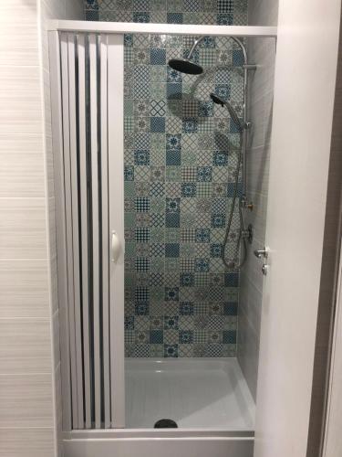 a shower in a bathroom with a tiled wall at Villaggio Silvia in Castellabate