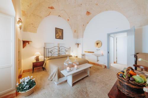 um quarto com uma cama e uma mesa com uma cesta de frutas em Masseria Ancella em Montalbano