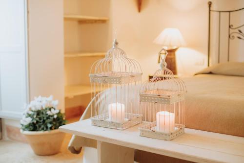 two bird cages with candles on a table in a bedroom at Masseria Ancella in Montalbano