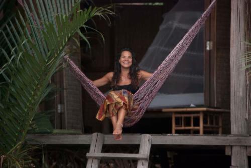 a woman is sitting on a hammock at Eden Eco Village in Kampot