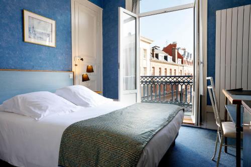 Cette chambre comprend un lit et une grande fenêtre. dans l'établissement Grand Hotel de L'Univers, à Amiens