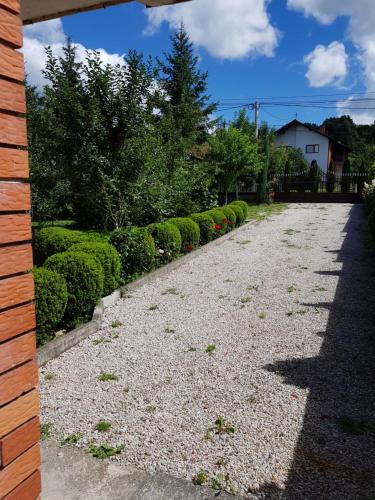a gravel driveway with bushes and a house at Apartment Paradise Enver in Dubrave Gornje