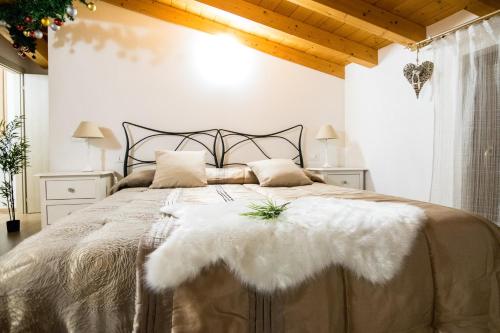 a bedroom with a large bed with a white blanket at B&B AL VICOLO DI MEZZO in Monzambano