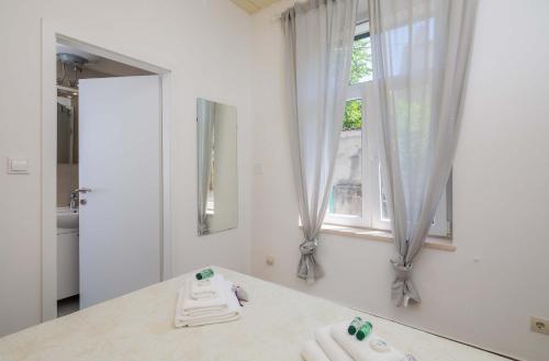 a bathroom with two white towels on a counter and a window at PLR-Royal luxury apartment in Split