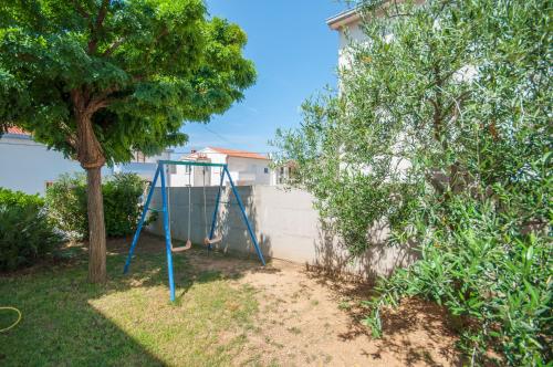 a blue swing in a yard with a tree at modern in Duće