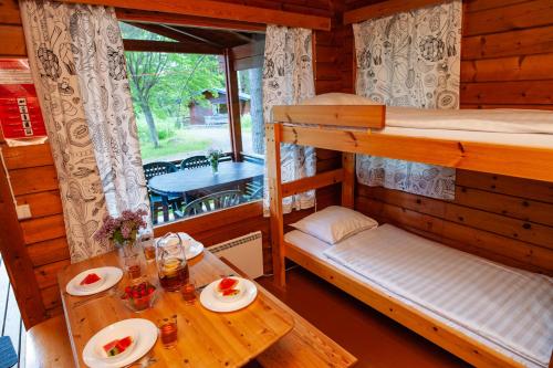 a room with two bunk beds and a table at Rauhalahti Holiday Cottages in Kuopio