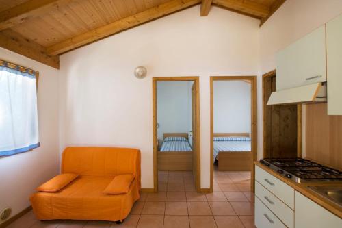 eine Küche mit einem orangenen Stuhl in einem Zimmer in der Unterkunft Camping Village Africa in Albinia