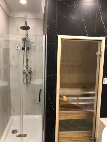 a shower with a glass door in a bathroom at Family & Business Sauna Apartments Paderewskiego Sienkiewicza No2 Centrum Downtown - 2 Bedroom with Private Sauna, Bath with Hydromassage, Parking in Kielce