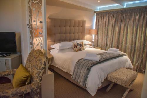 a bedroom with a large bed and a chair at Clarens Retreat in Clarens