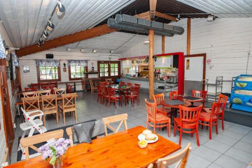 an empty restaurant with wooden tables and chairs at Rauhalahti Holiday Homes in Kuopio