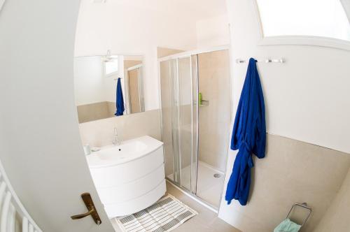 Un baño blanco con lavabo y ducha. en Charming villa Il Motto with pool, en Cissano