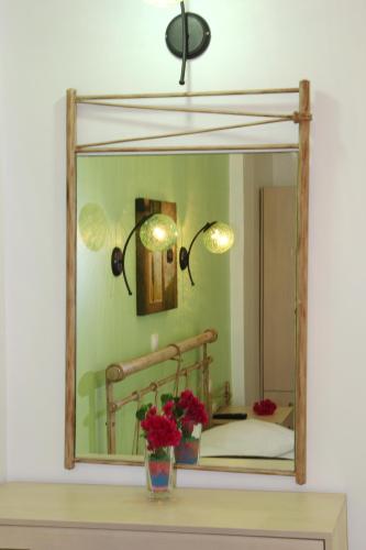 a mirror on top of a table with flowers at Coralli Rooms & Restaurant in Elafonisos