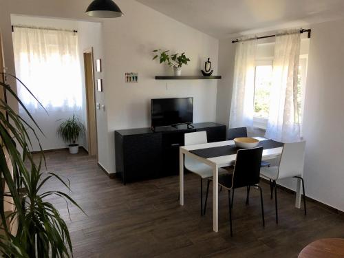 a living room with a table and chairs and a television at Fine & Shine in Pula