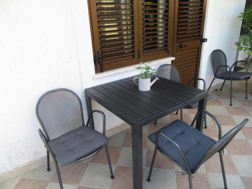 Apartment Sara في نجيفيش: طاولة سوداء وكراسي عليها خزاف
