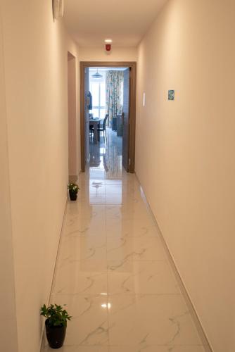 a hallway with a tile floor in a building at For Rest Aparthotel in St Paul's Bay