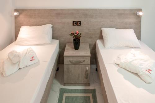 two beds in a room with white pillows at For Rest Aparthotel in St Paul's Bay
