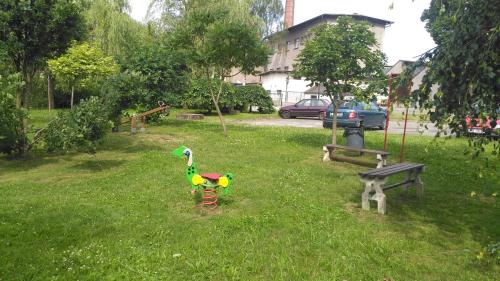 a toy duck sitting in the grass next to a bench at Ubytování u Šveců u Adršpachu in Jívka