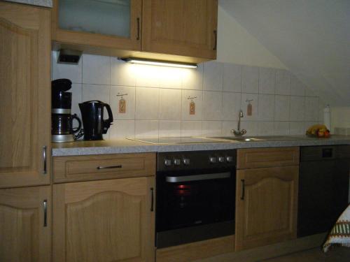 una cocina con armarios de madera y horno negro en Apartment Schoenblick, en Winterberg