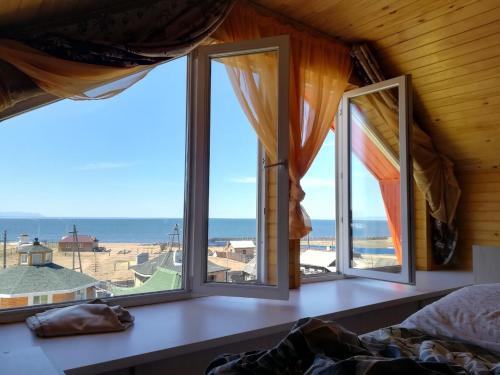 a large window overlooking a beach with a view of the ocean at Mebis Baikal in Turkinski