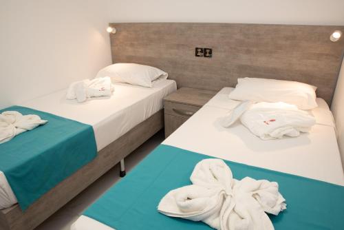 two beds with towels on them in a room at For Rest Aparthotel in St Paul's Bay