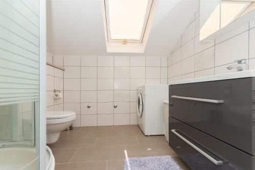 a bathroom with a toilet and a sink and a window at modern in Duće