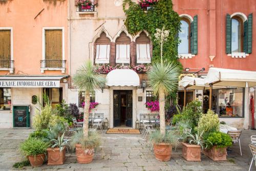 a street with potted plants in front of a building at Hotel Santo Stefano in Venice