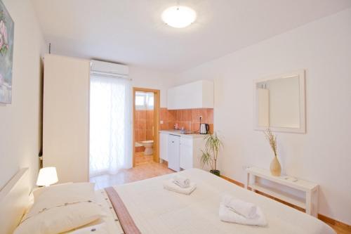 Dieses weiße Zimmer verfügt über 2 Betten und eine Küche. in der Unterkunft Villa Ivana in Makarska